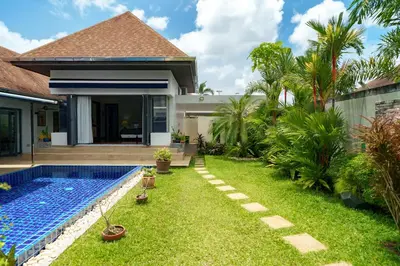 a backyard with a swimming pool and a house at Henia Villa by G Estate Phuket in Ban Saiyuan (1)