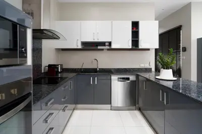 a kitchen with white cabinets and a stainless steel dishwasher at Henia Villa by G Estate Phuket in Ban Saiyuan (1)