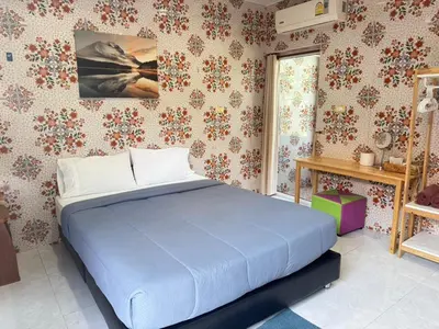a bedroom with a blue bed in a room with wallpaper at Jampathong mansion in Ban Bo Han