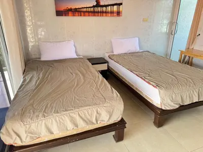 two beds sitting next to each other in a room at Jampathong mansion in Ban Bo Han