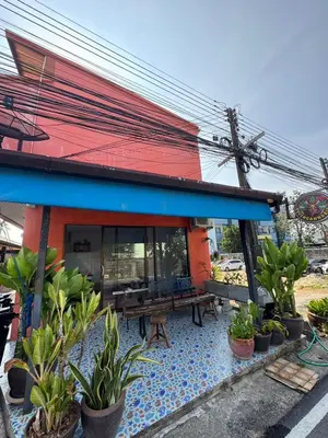 a building with a patio with a table and potted plants at Jampathong mansion in Ban Bo Han