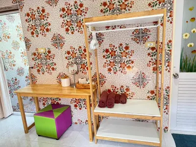 a room with a desk and a table and a wall at Jampathong mansion in Ban Bo Han