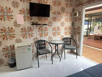 a room with a table and two chairs and a television at Jampathong mansion in Ban Bo Han
