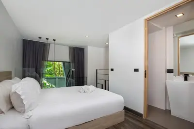a bedroom with a white bed and a bath tub at Duplex Naiharn UTL A123 - Perfect Stay near Beach in Rawai Beach