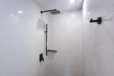a bathroom with a shower with white tiles at Duplex Naiharn UTL A123 - Perfect Stay near Beach in Rawai Beach
