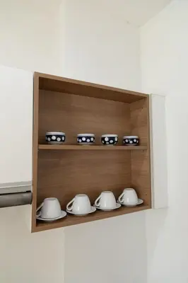 a shelf with a bunch of tea pots and bowls at At Sea condo Building C, Klong Muang Beach in Ban Ko Kwang