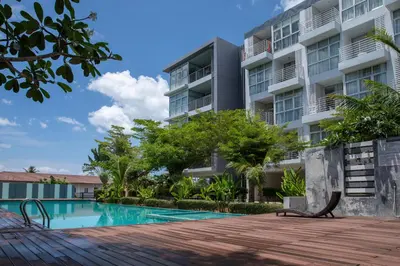 a swimming pool in front of a building at At Sea condo Building C, Klong Muang Beach in Ban Ko Kwang