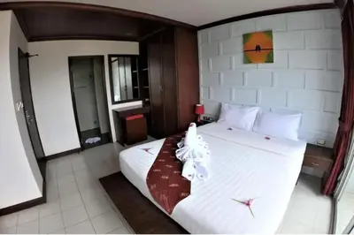 a bedroom with a large bed with white sheets at EBS Hostel Phuket in Karon Beach