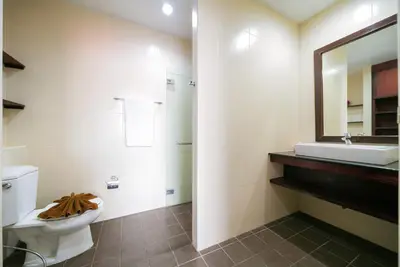a bathroom with a toilet and a sink and a mirror at EBS Hostel Phuket in Karon Beach