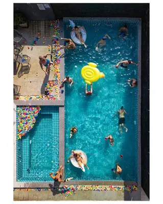 a group of people swimming in a swimming pool at EBS Hostel Phuket in Karon Beach