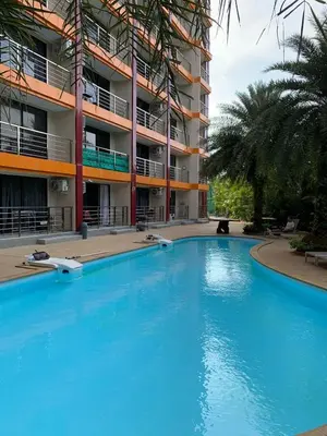a large blue swimming pool in front of a building at Студия мечтателя in Mai Khao Beach