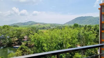a balcony with a view of a river and mountains at Студия мечтателя in Mai Khao Beach