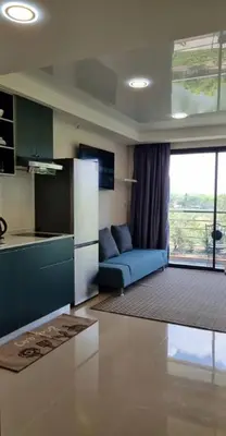 a living room with a blue couch and a kitchen at Студия мечтателя in Mai Khao Beach