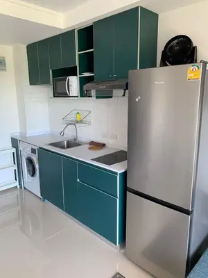 a kitchen with green cabinets and a refrigerator at Студия мечтателя in Mai Khao Beach