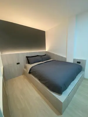 a bedroom with a large bed with a black comforter at Apartment in Rawai in Ban Saiyuan (1)