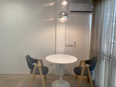 a table and chairs in a room with a lamp at Apartment in Rawai in Ban Saiyuan (1)