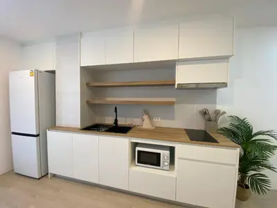 a kitchen with white cabinets and a white refrigerator at Apartment in Rawai in Ban Saiyuan (1)