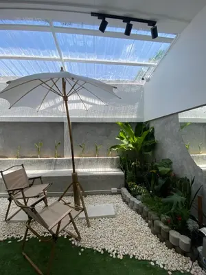 a patio with a chair and an umbrella at Apartment in Rawai in Ban Saiyuan (1)
