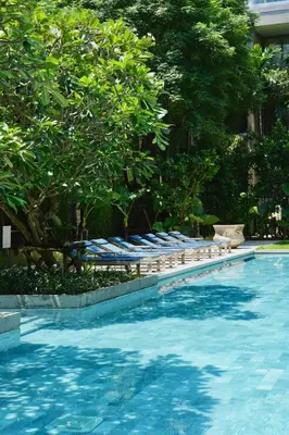 a swimming pool with chaise lounges and trees at Luxury 3-Bedroom Sea View Apartment in MontAzure Kamala in Surin Beach