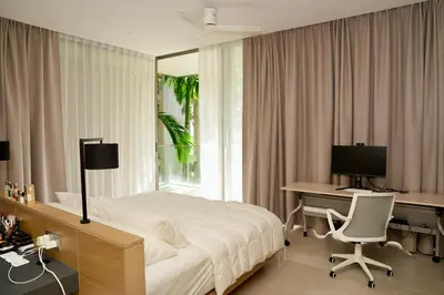 a bedroom with a bed and a desk and a computer at Luxury 3-Bedroom Sea View Apartment in MontAzure Kamala in Surin Beach