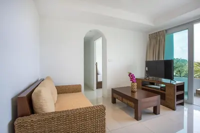 a living room with a couch and a tv at Scenic Kata SeaView Condo O17-1BR just 5 min Drive to Kata Beach in Karon Beach