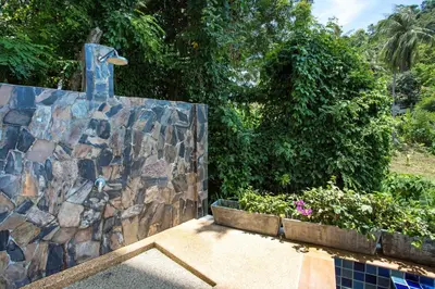 a stone wall with a statue in a garden at Scenic Kata SeaView Condo O17-1BR just 5 min Drive to Kata Beach in Karon Beach