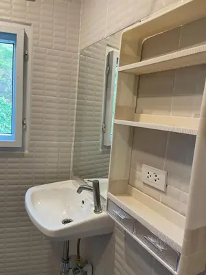 a white bathroom with a sink and a mirror at Baan Sangchai Beach in Ko Bon