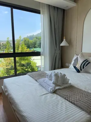 a bedroom with two beds with a large window at Two-bedrooms apartments with kitchen in Phuket Town