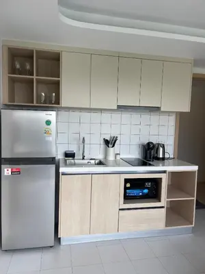 a kitchen with white cabinets and a refrigerator at Two-bedrooms apartments with kitchen in Phuket Town