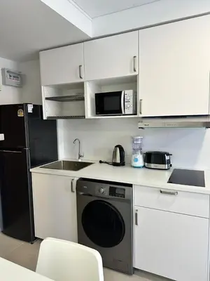 a small kitchen with a sink and a microwave at New Apartment in 777 BEACH CONDO in Ban Mai Salae