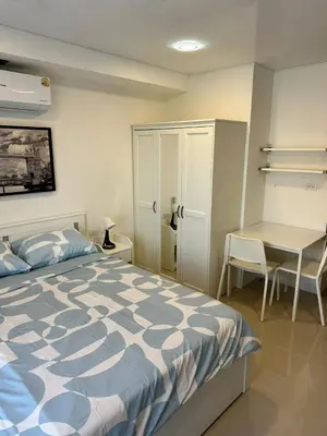 a bedroom with a bed and a table and a desk at New Apartment in 777 BEACH CONDO in Ban Mai Salae