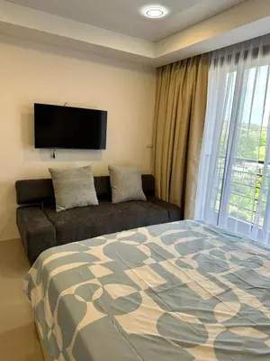a bedroom with a bed and a couch and a flat screen tv at New apartment with mountain view in Ban Mai Salae