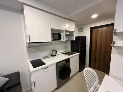 a small kitchen with white cabinets and a microwave at New apartment with mountain view in Ban Mai Salae