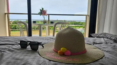 a hat and a pair of sunglasses and a hat and glasses at Sunset view studio at 777 Beach Condo in Ban Mai Salae