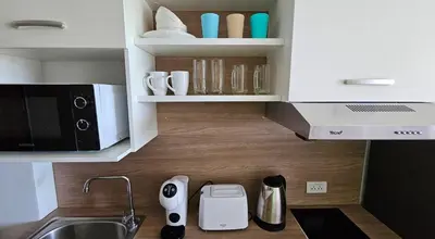 a kitchen with white cabinets and a counter top with a sink at Sunset view studio at 777 Beach Condo in Ban Mai Salae
