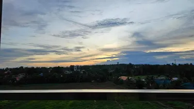 a view of a cloudy sky with trees and a road at Sunset view studio at 777 Beach Condo in Ban Mai Salae
