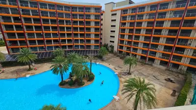 an overhead view of a swimming pool with palm trees and buildings at Sunset view studio at 777 Beach Condo in Ban Mai Salae