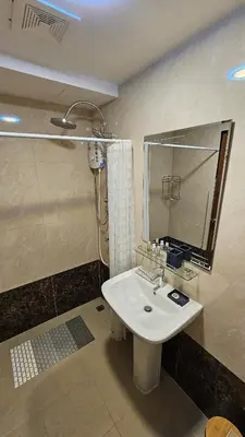 a bathroom with a sink and a shower and a mirror at Sunset view studio at 777 Beach Condo in Ban Mai Salae