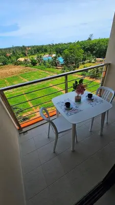 a white table and chair on a balcony with a view at Sunset view studio at 777 Beach Condo in Ban Mai Salae