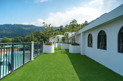 a view from the balcony of a house with green grass at Kamala Beach View 1 BdR Roof Pool 500 mbps WiFi in Kamala Beach