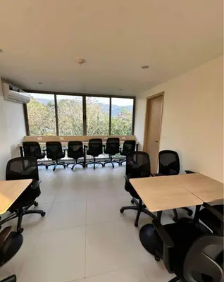 a classroom with tables and chairs in a room with windows at One-bedroom apartments with kitchen in Phuket Town