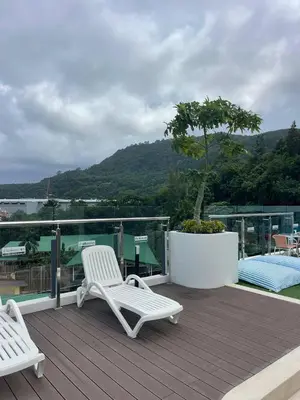 two white chairs sitting on the deck of a house at One-bedroom apartments with kitchen in Phuket Town