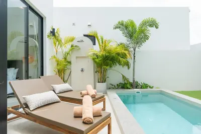 a living room with a pool and a couch and a swimming pool at Staylar Pool Villas - Bangtao in Ban Pak Lak