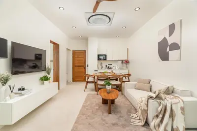 a living room with a couch and a table at Staylar Pool Villas - Bangtao in Ban Pak Lak