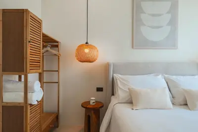 a bedroom with a bed with white pillows at Staylar Pool Villas - Bangtao in Ban Pak Lak