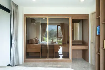 a bedroom with a glass door with a bed in it at Luxury Pool Access 2BR Patong in Patong Beach