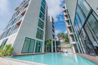 a swimming pool in front of a building at Luxury Pool Access 2BR Patong in Patong Beach