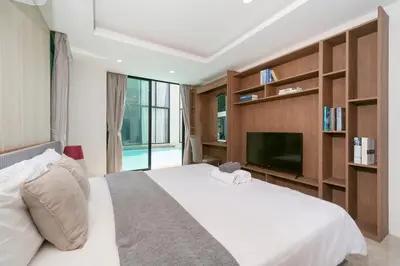 a bedroom with a white bed and a tv at Luxury Pool Access 2BR Patong in Patong Beach