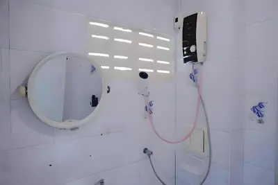 a bathroom with a round mirror and a sink at XX BAO Patong Beach Phuket - เบาป่าตองบีช in Patong Beach