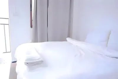 a bed with white sheets and pillows in a room at XX BAO Patong Beach Phuket - เบาป่าตองบีช in Patong Beach